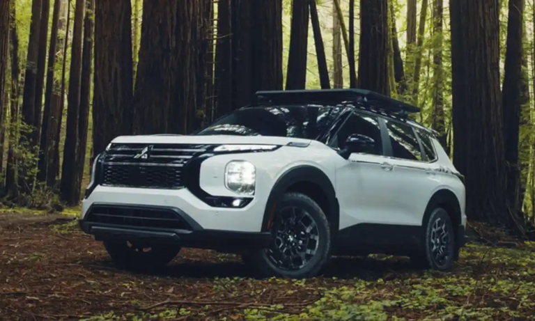 2026 Mitsubishi Outlander SUV parked on a forest trail, showcasing its rugged design and adventure-ready capability.