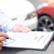 Buyer reviewing vehicle insurance documents before VIN verification for car export from Dubai.