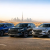 Three 7-seater SUVs on a Dubai road with the city skyline in the background